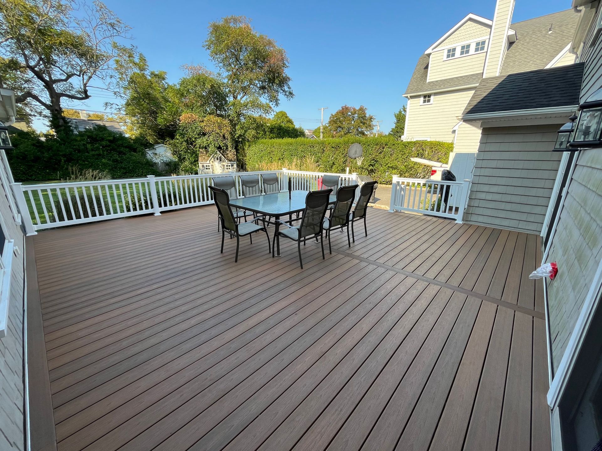 A large wooden deck with a table and chairs on it.