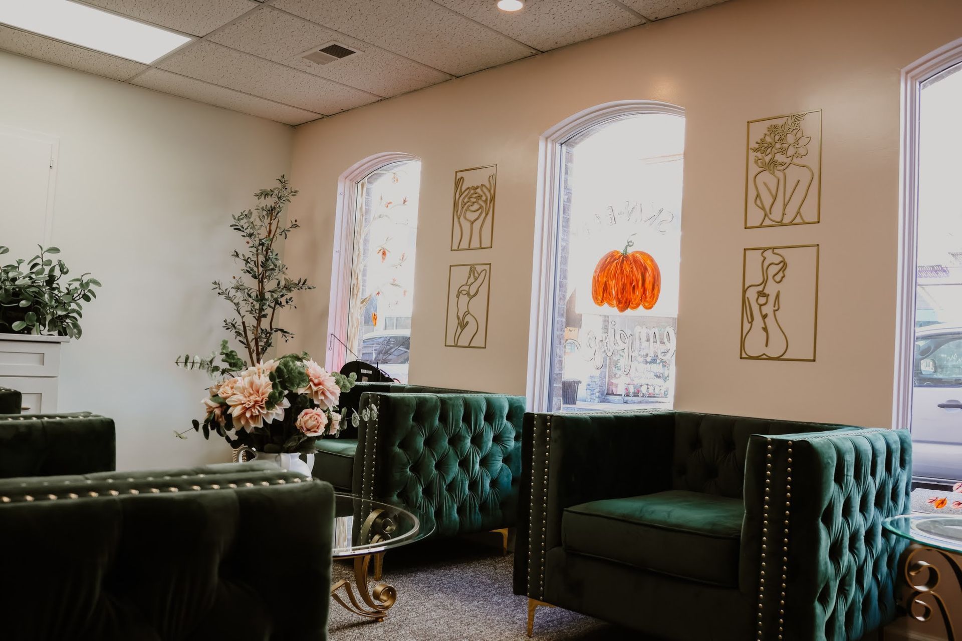 A waiting room with green chairs and a pumpkin hanging from the ceiling.
