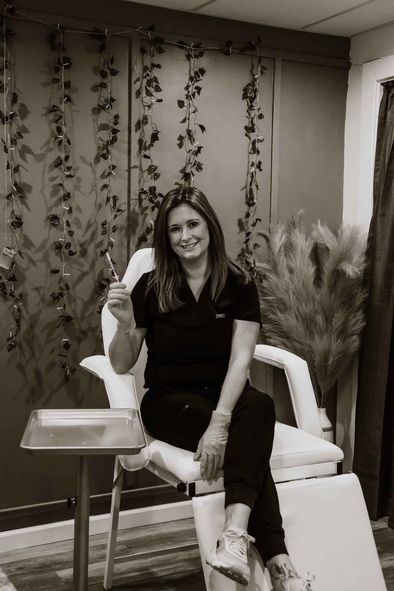 A woman is sitting in a chair holding a glass of wine.