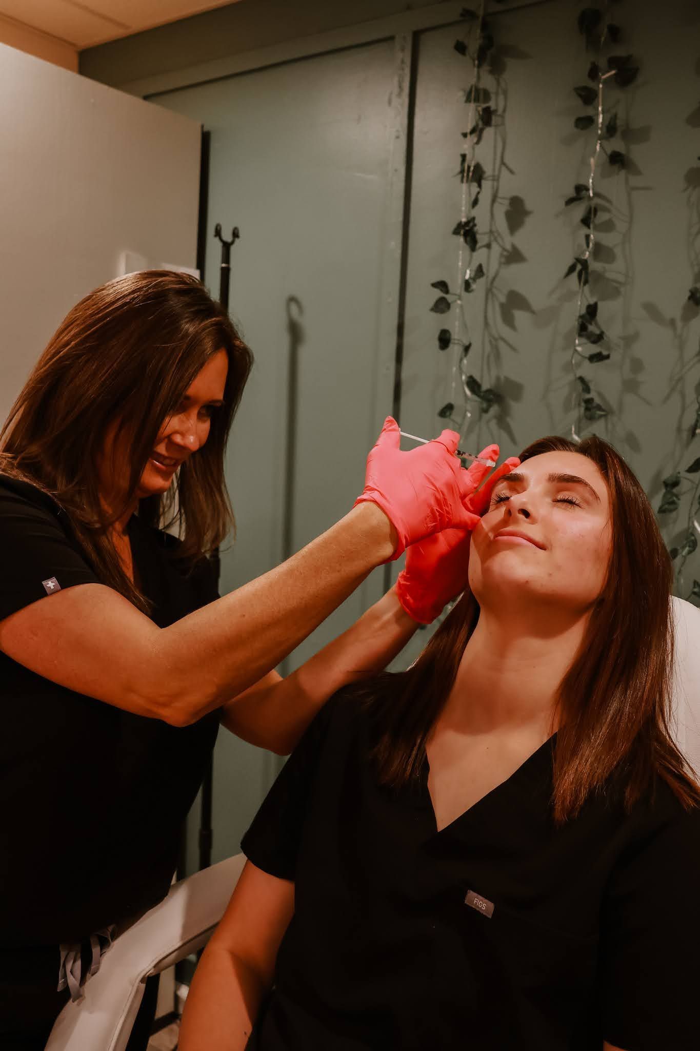 A woman is getting a botox injection in her eye.