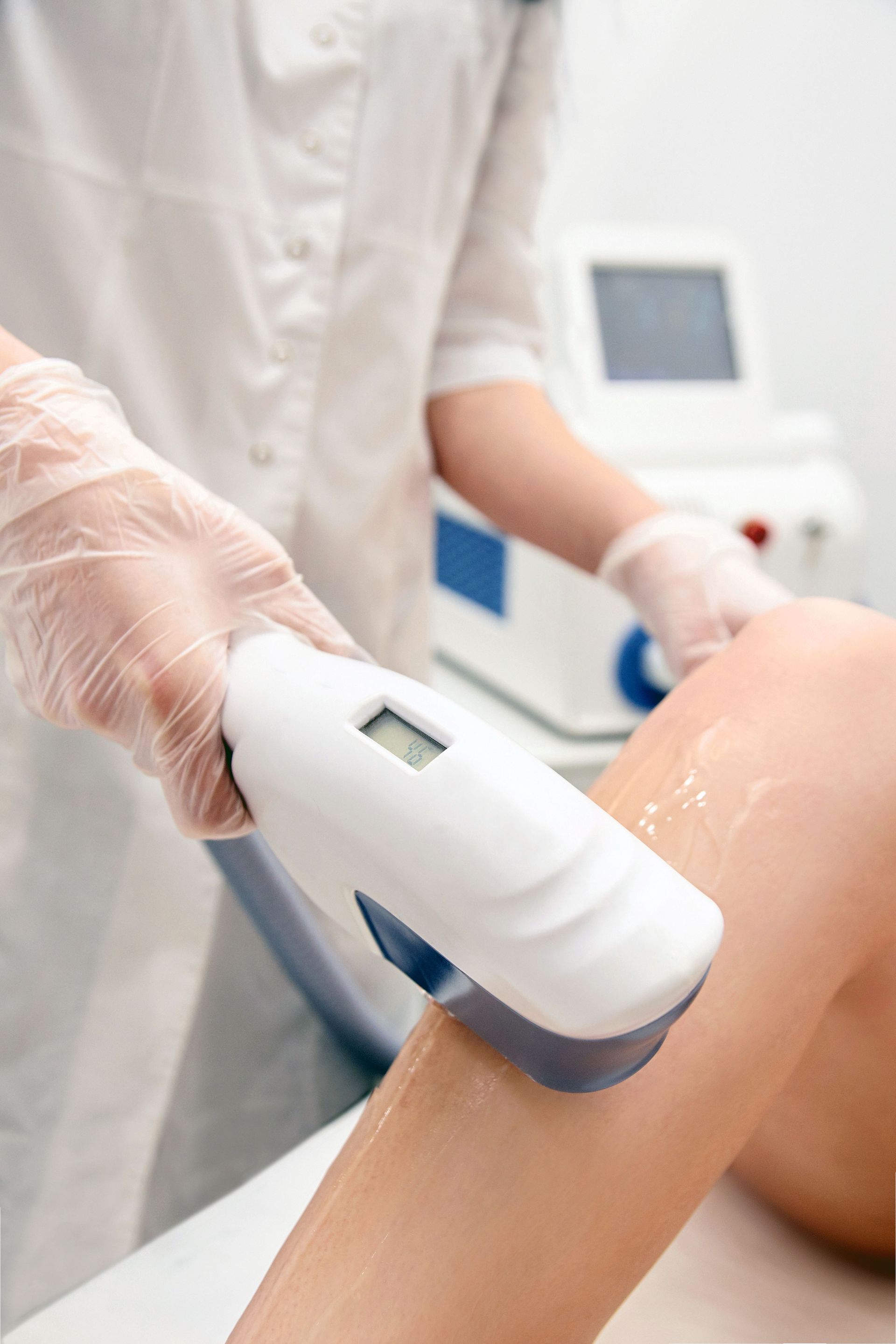 A woman is getting a laser hair removal treatment on her leg.