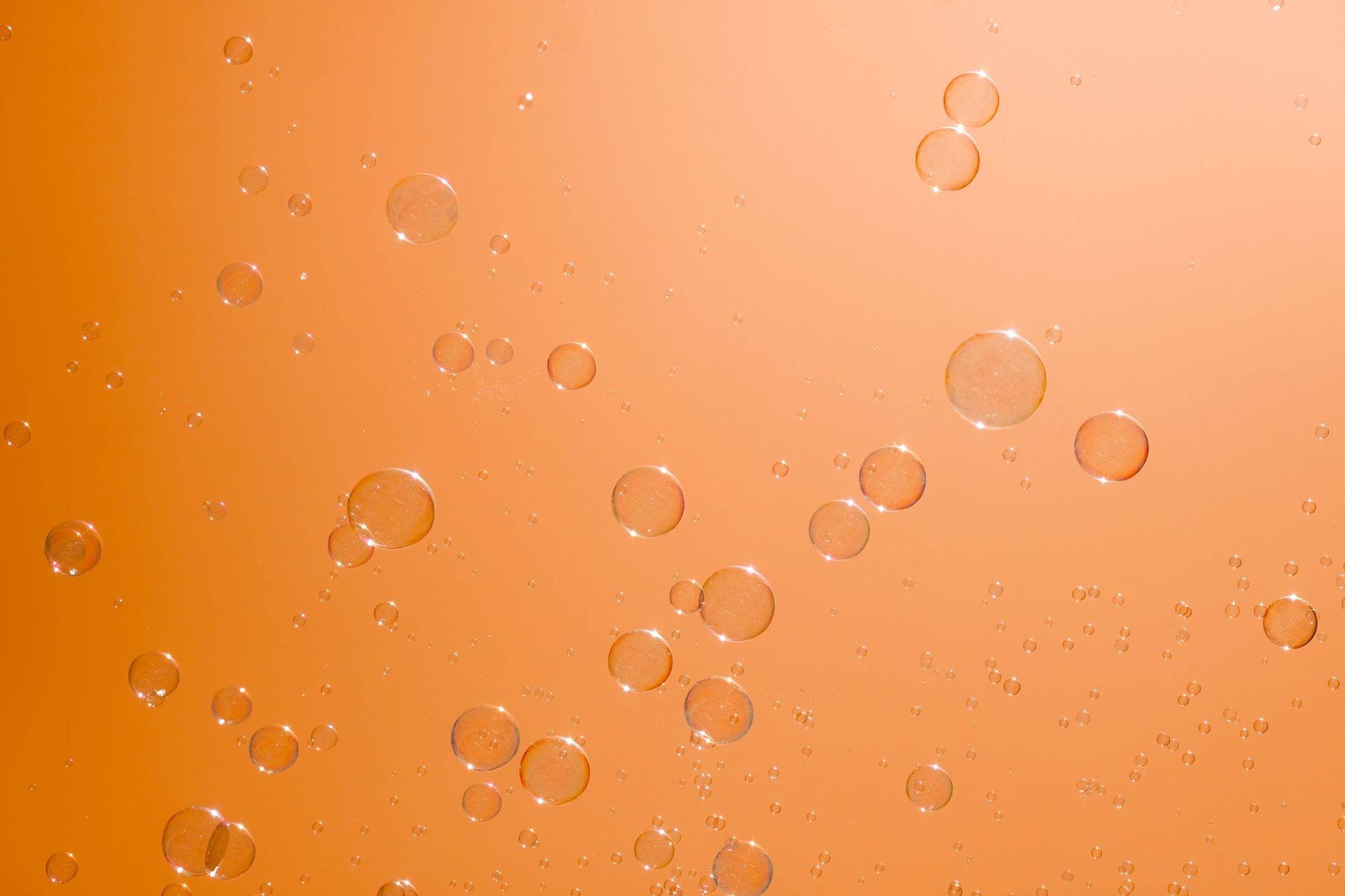 The bubbles are floating in the orange liquid.
