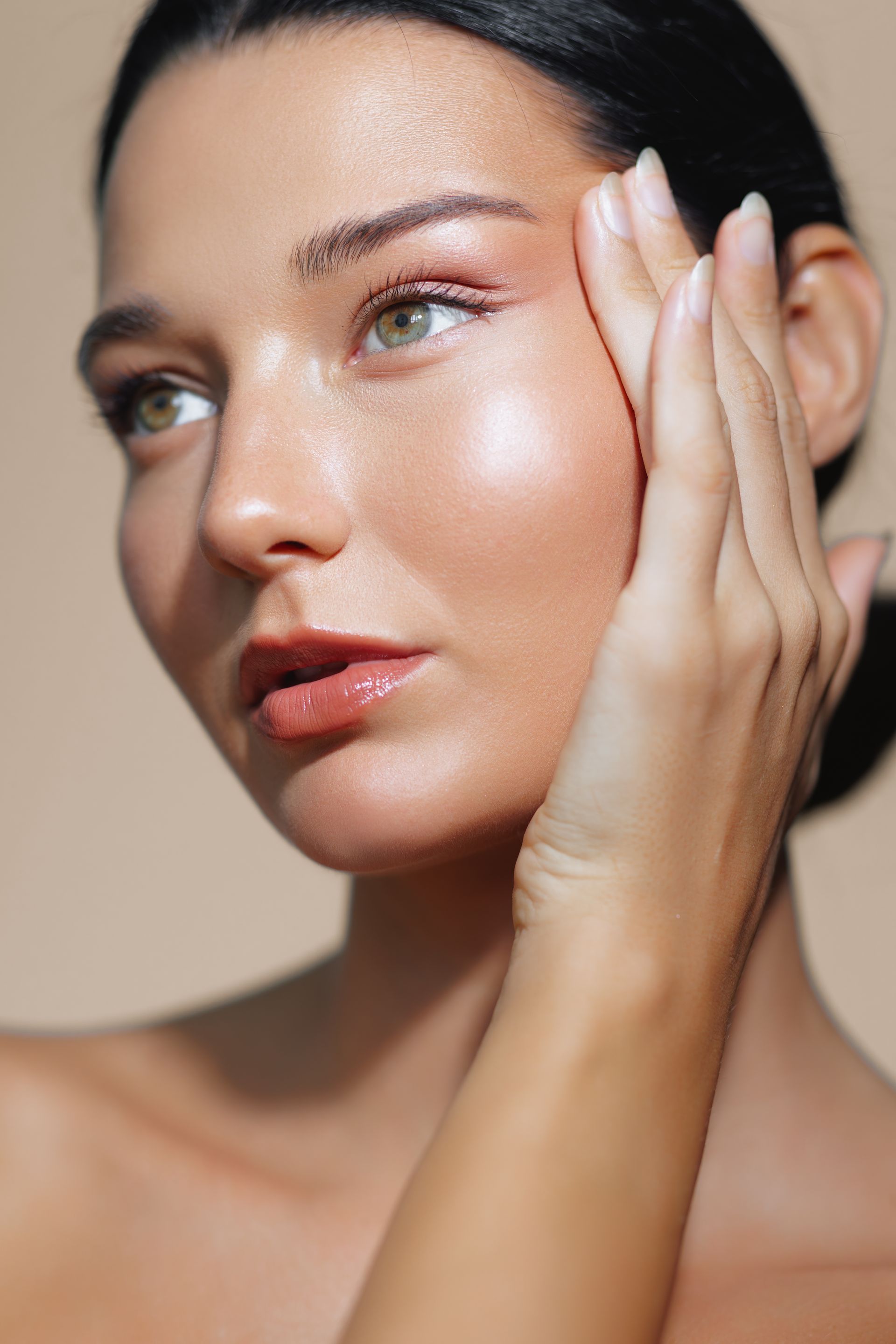 A close up of a woman 's face with her hand on it.