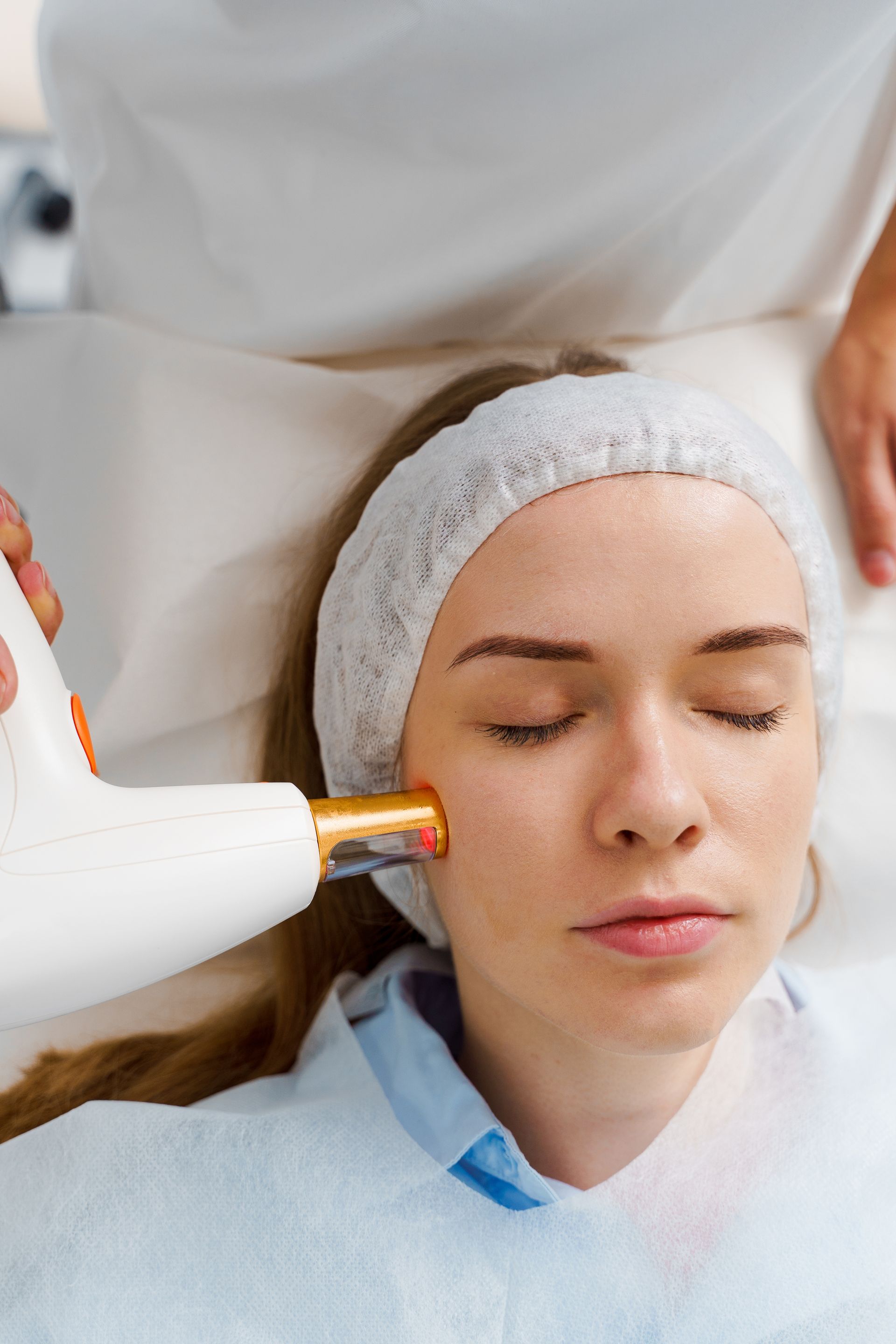A woman is getting a laser treatment on her face.