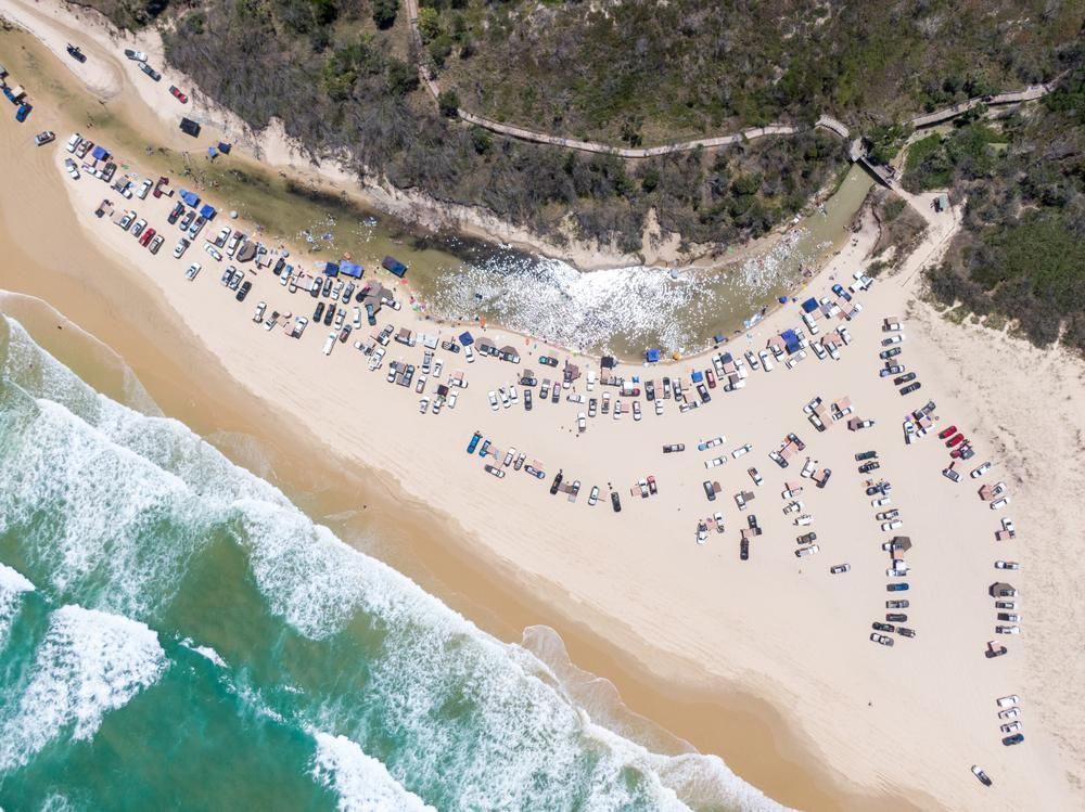 An Aerial View of a Beach With a Lot of Cars Parked on It — NLJ Partners P/L In Wyong, NSW