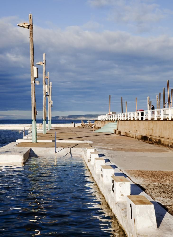 A Row of Benches Along a Pier Next to a Body of Water — NLJ Partners P/L In Wyong, NSW