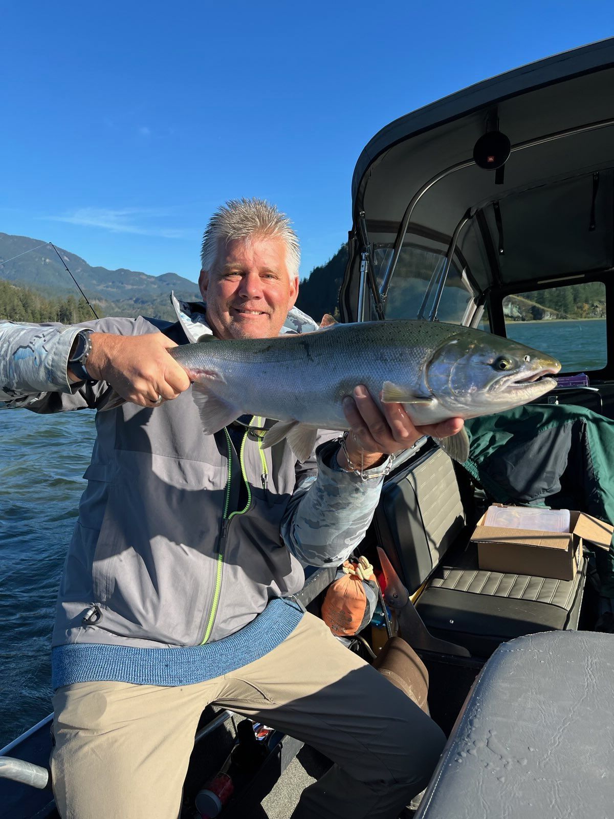 Man sitting on boat with fish.