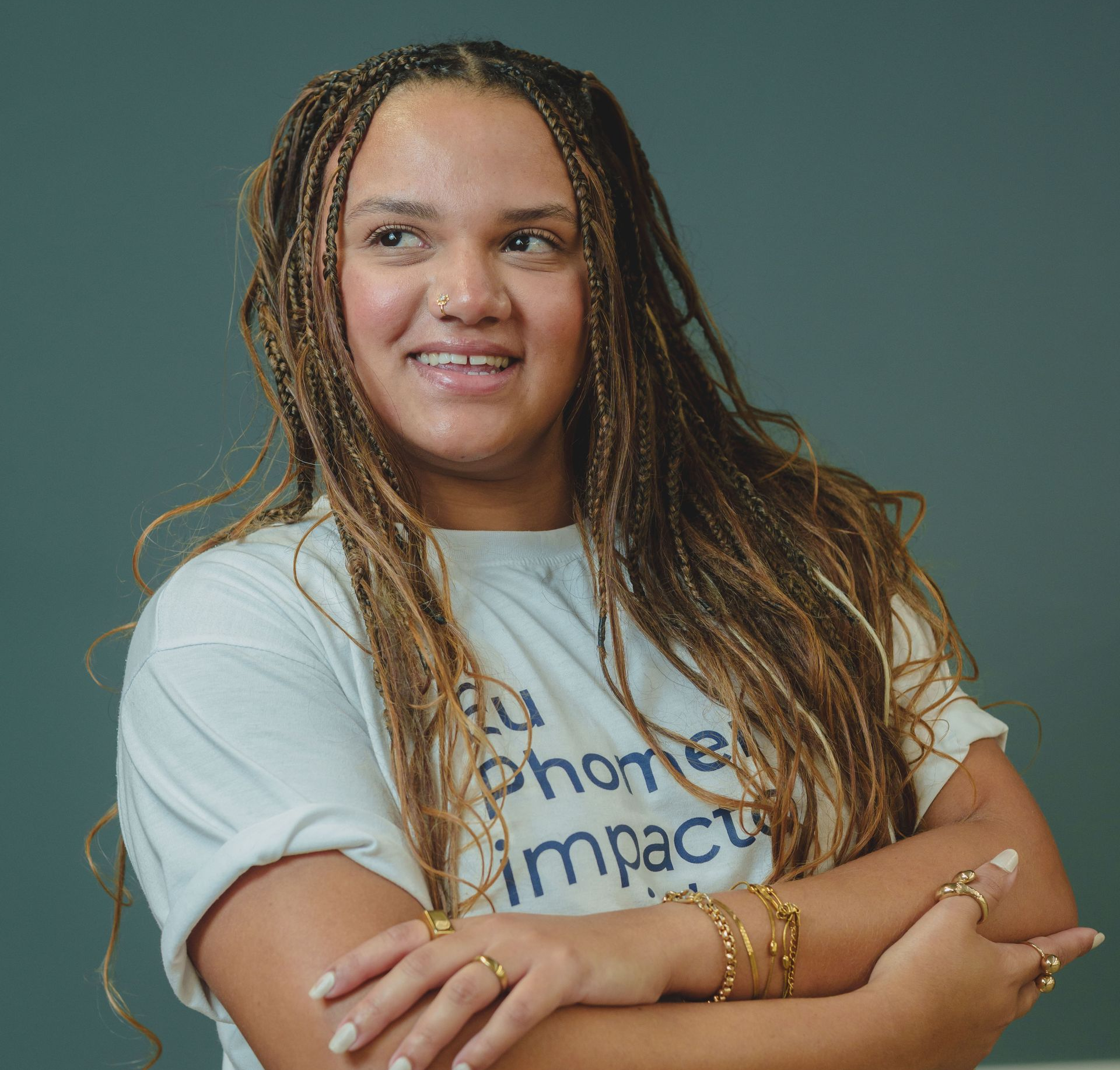 Mulher com tranças loiras sorrindo para a câmera.