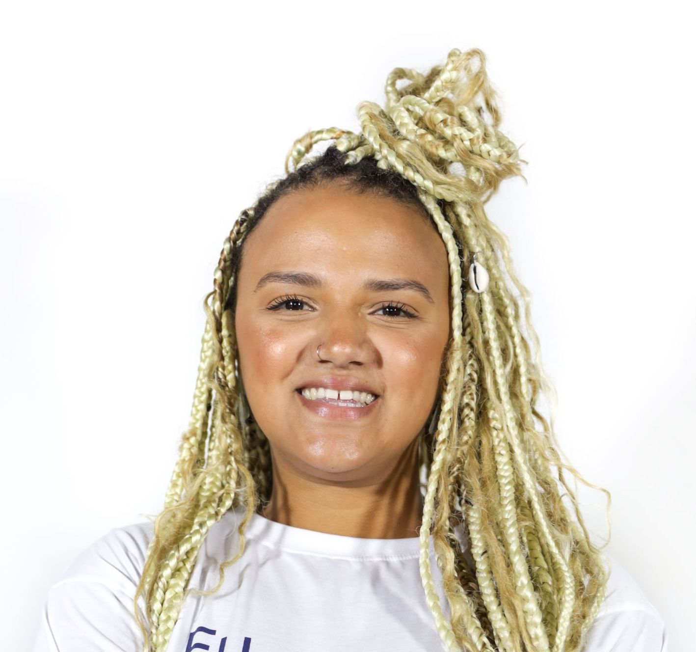 Mulher com tranças loiras sorrindo para a câmera.