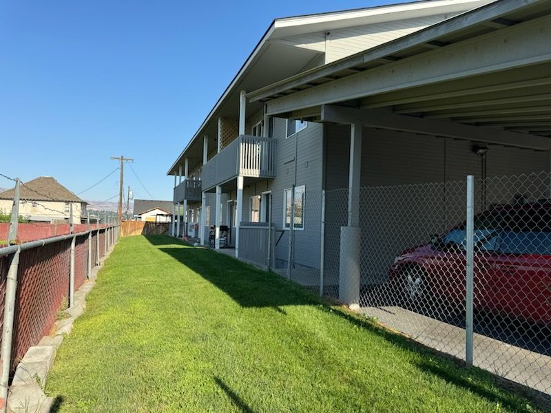 A building with a red car parked underneath it