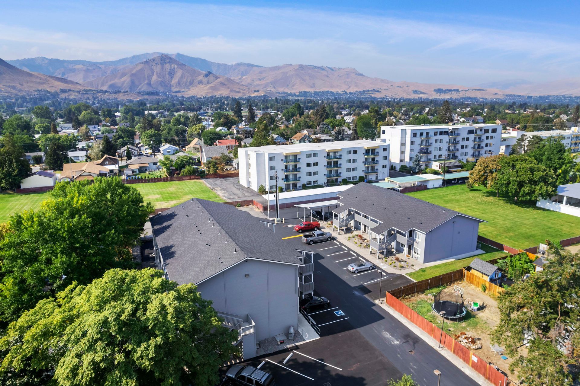 An aerial view of a apartment complex with mountains in the background.