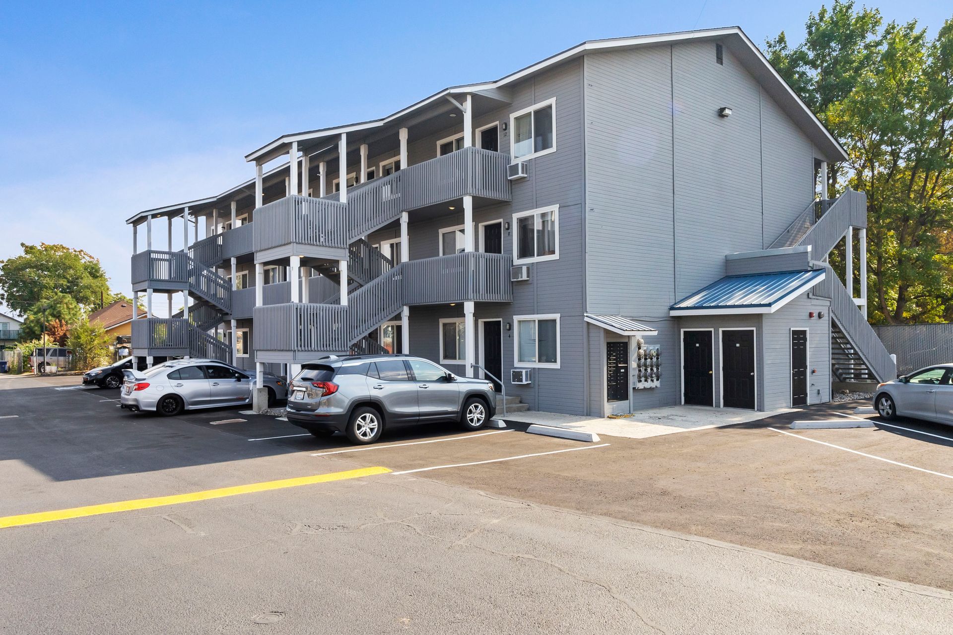 A large apartment building with cars parked in front of it