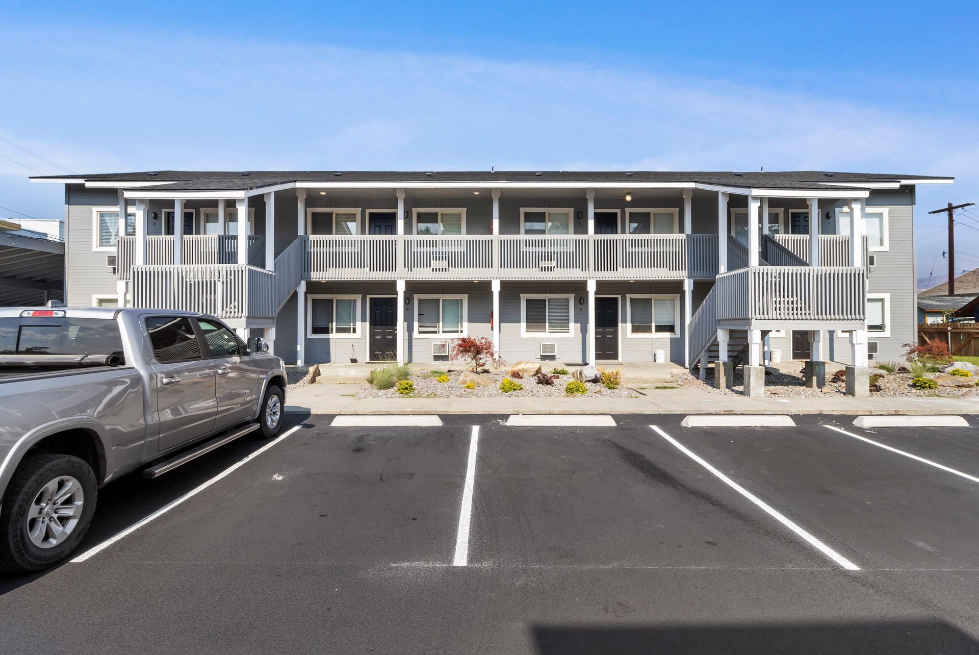 A truck is parked in front of a large apartment building.