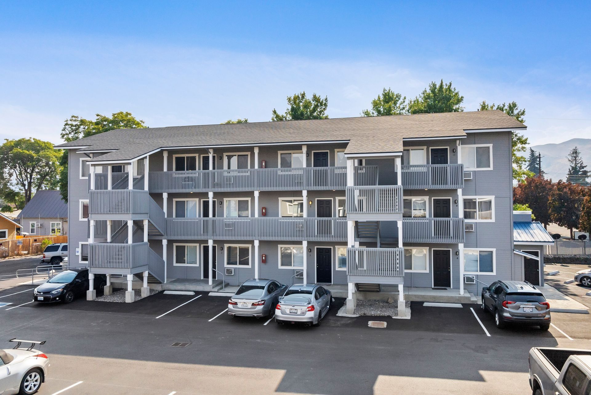 A large apartment building with cars parked in front of it