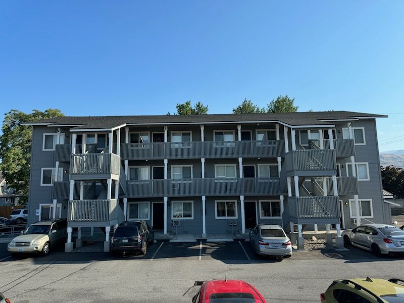 A large apartment building with cars parked in front of it