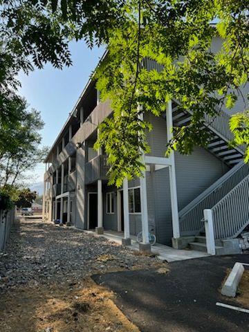 A building with stairs and a tree in front of it