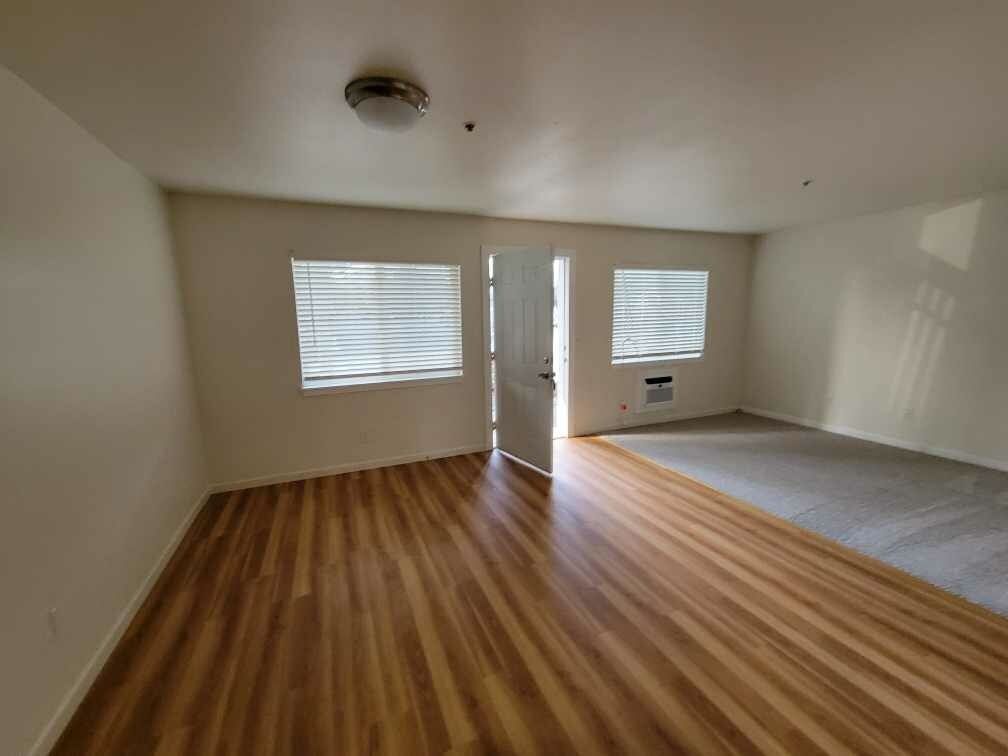 An empty room with wooden floors and white walls.