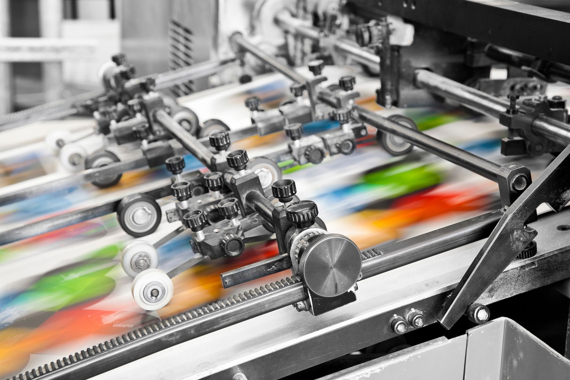 Close-up of a commercial offset printing machine as it prints in color.