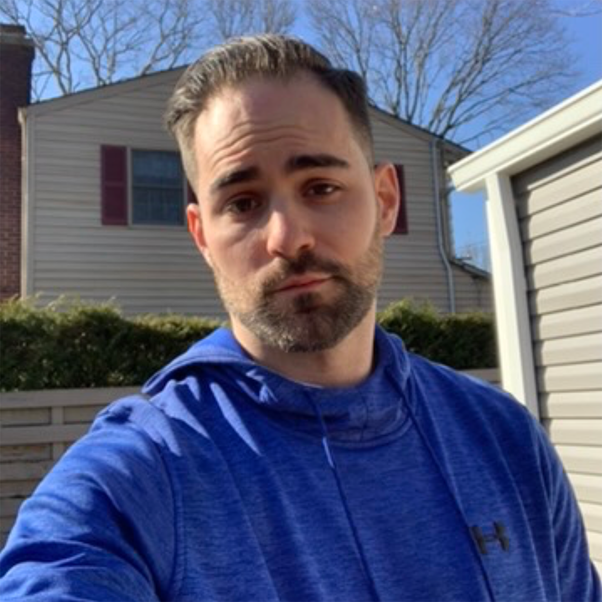 A man in a blue under armour hoodie takes a selfie