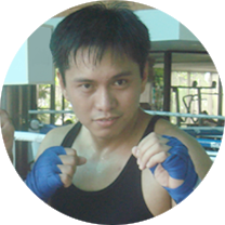 A man in a black tank top with blue boxing gloves