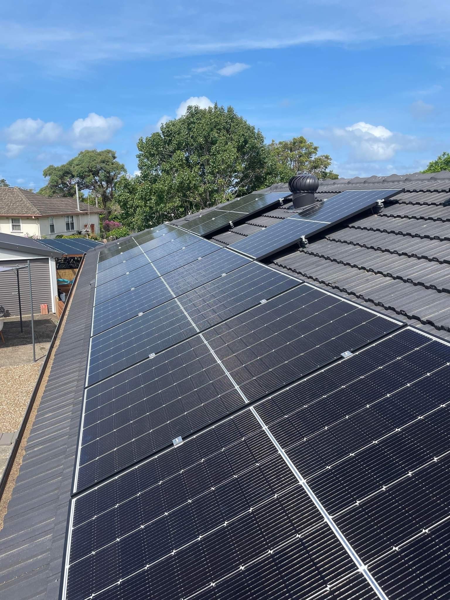 A Row of Solar Panels on The Roof of a House — JNQ Solar & Electrical in Woonona, NSW