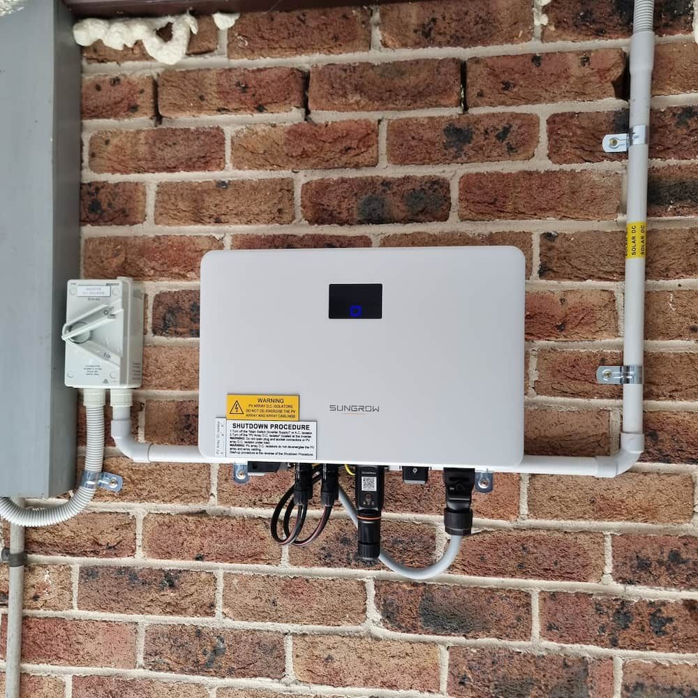 A White Box Mounted on a Brick Wall — JNQ Solar & Electrical in Campbelltown, NSW