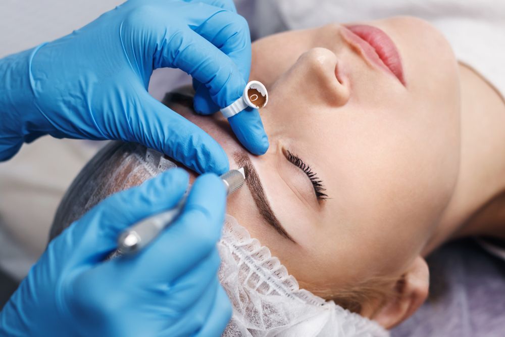A Woman is Getting a Permanent Makeup Tattoo on Her Eyebrows — Aqua Marine Skin and Beauty in Tuncurry, NSW