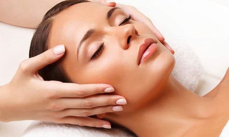 A Woman is Getting a Facial Massage at a Spa — Aqua Marine Skin and Beauty in Tuncurry, NSW
