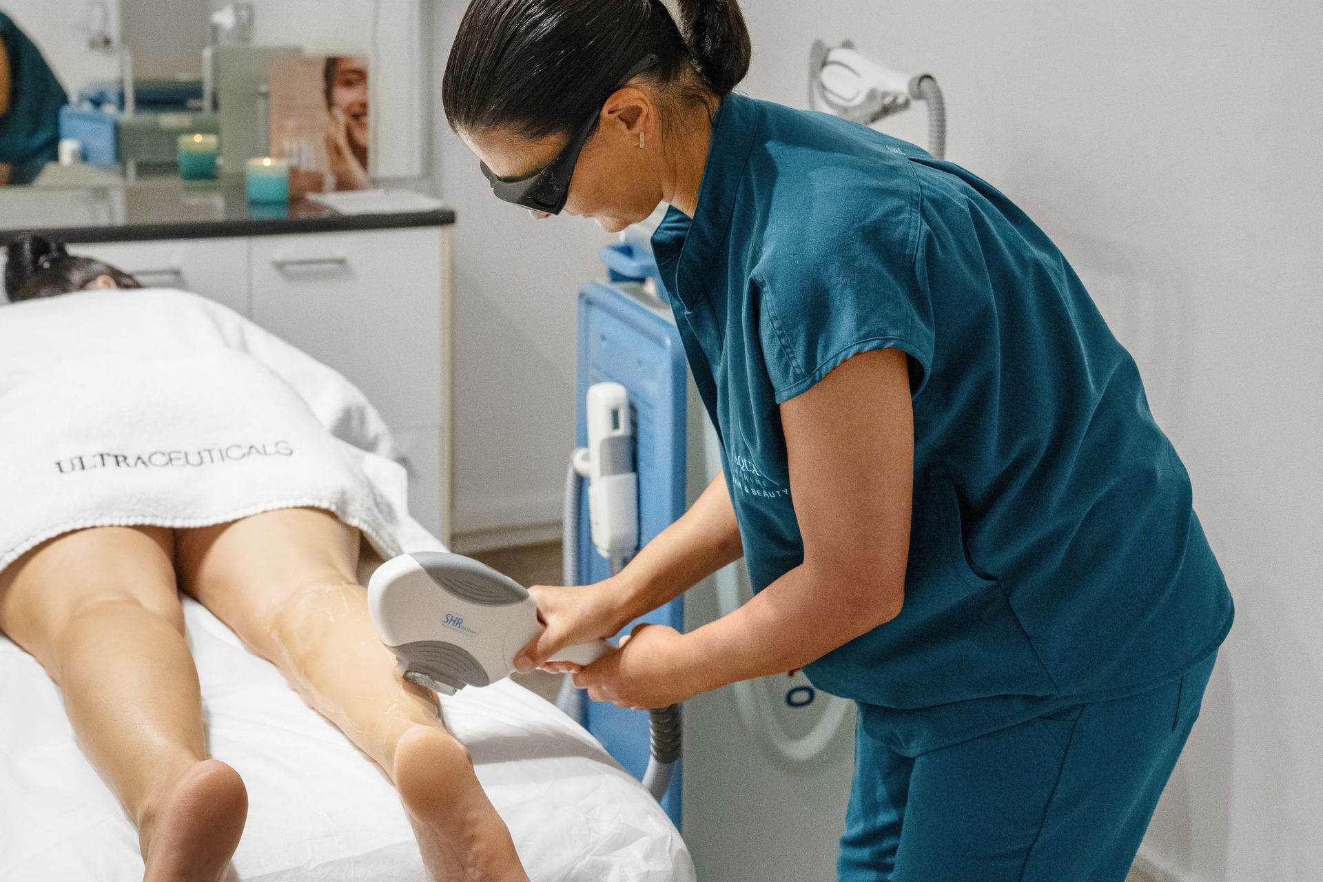 A person receiving laser hair removal treatment on their leg at a clinic  — Aqua Marine Skin and Beauty in Forster, NSW