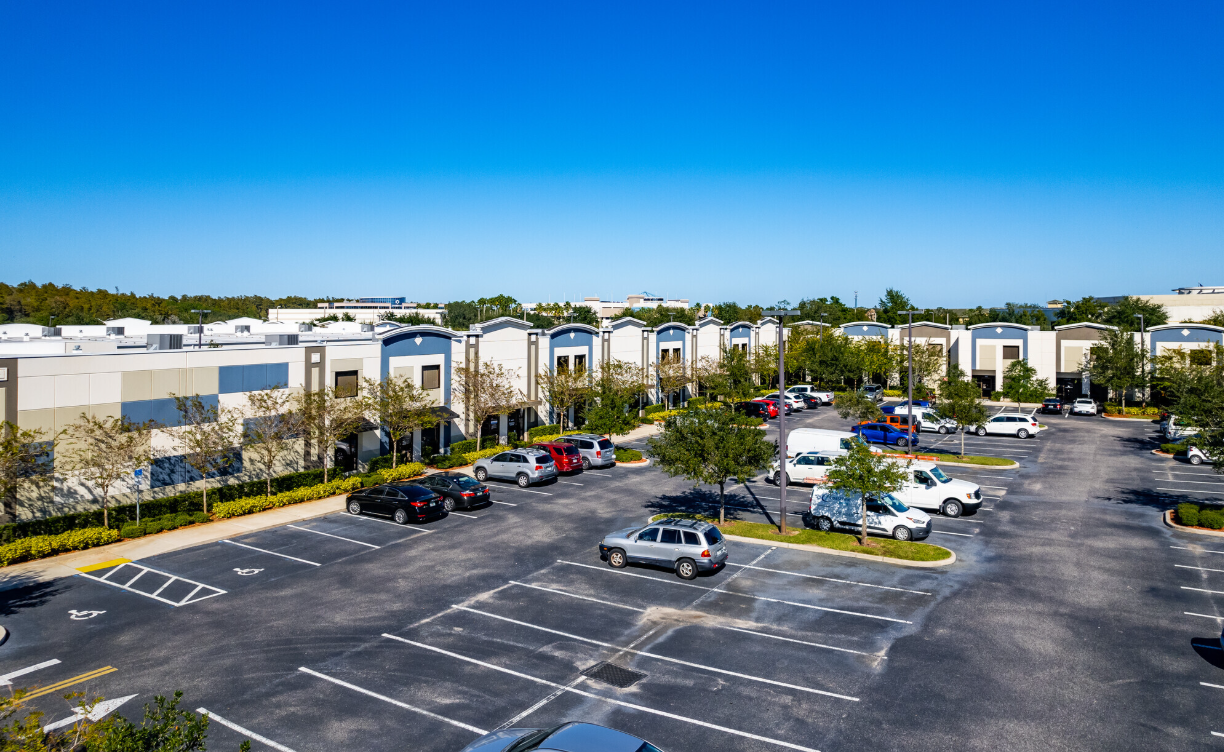 An aerial view of a parking lot in front of a building.