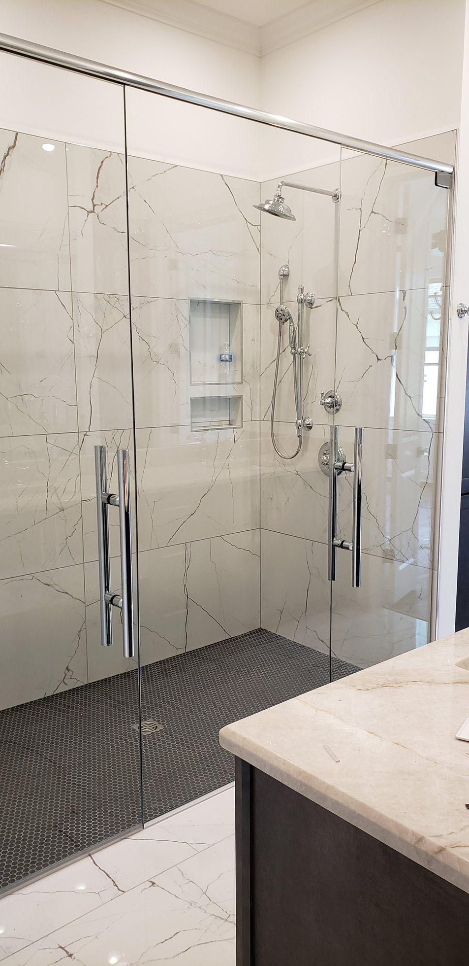 A bathroom with a walk in shower and a sink.