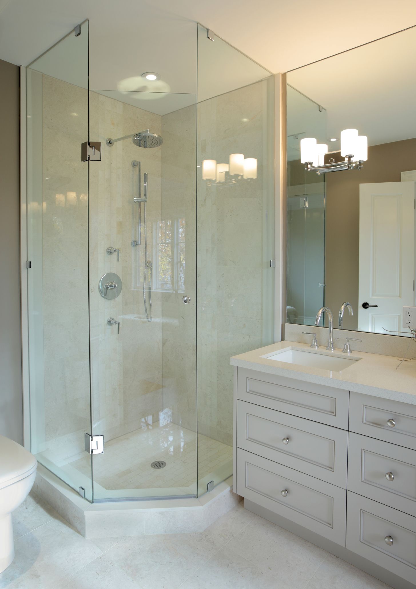 A modern bathroom with frameless shower doors, glass stall, and stylish contemporary fixtures.