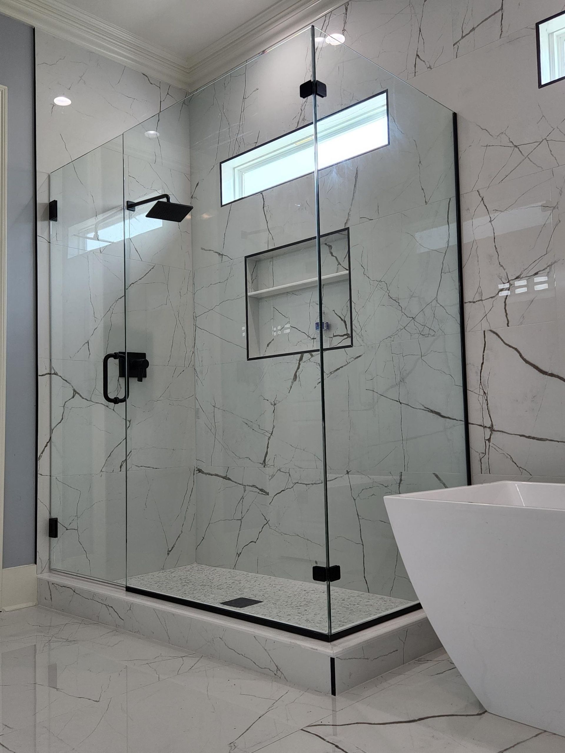 A bathroom with a walk in shower and a bathtub.