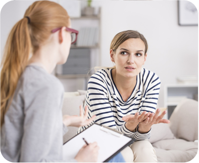 Woman talking to a therapist wearing a striped shirt
