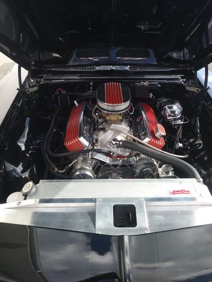 A close up of a car engine with the hood open.