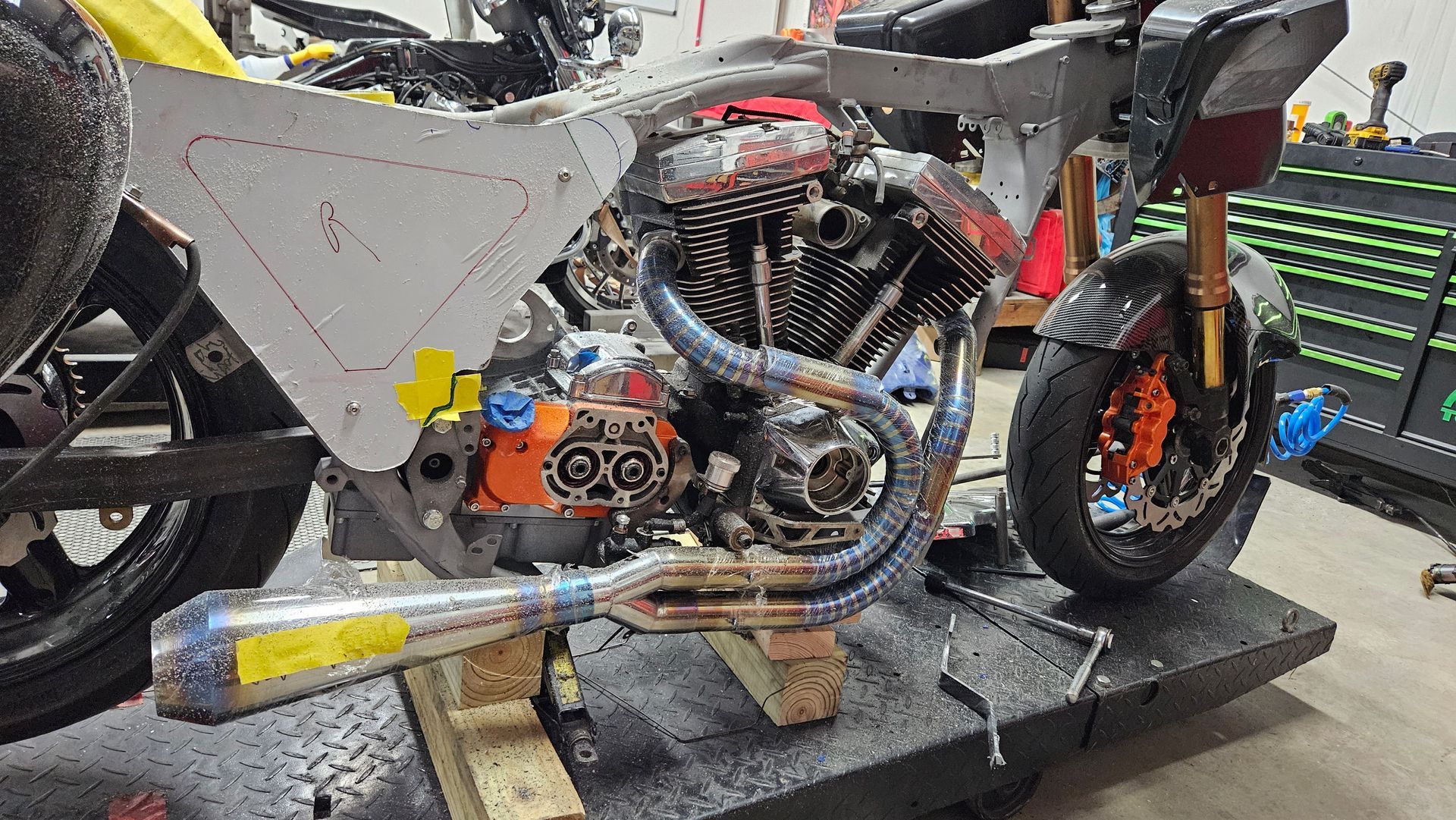 A motorcycle is sitting on top of a table in a garage.