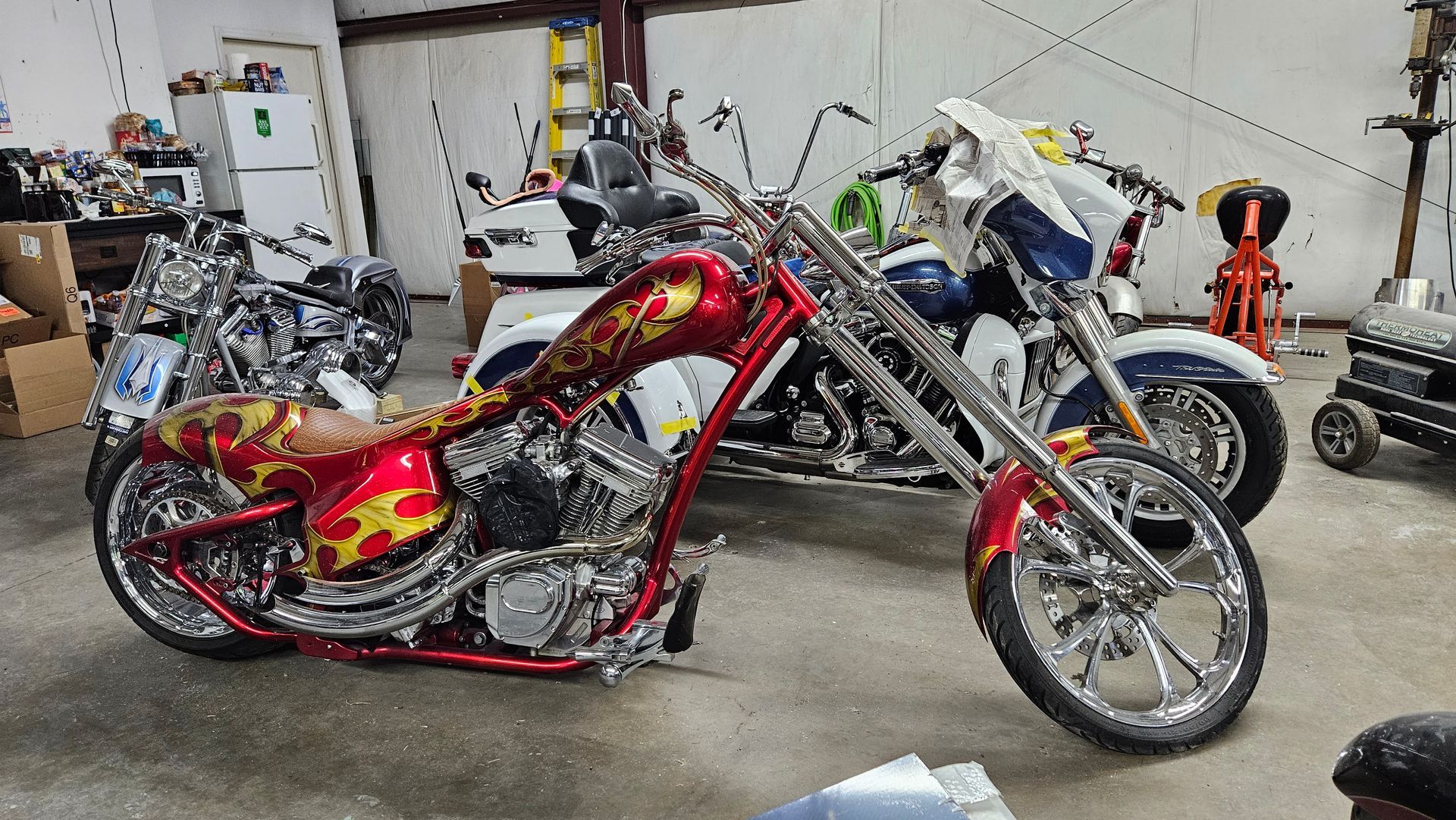 A row of motorcycles are parked in a garage.