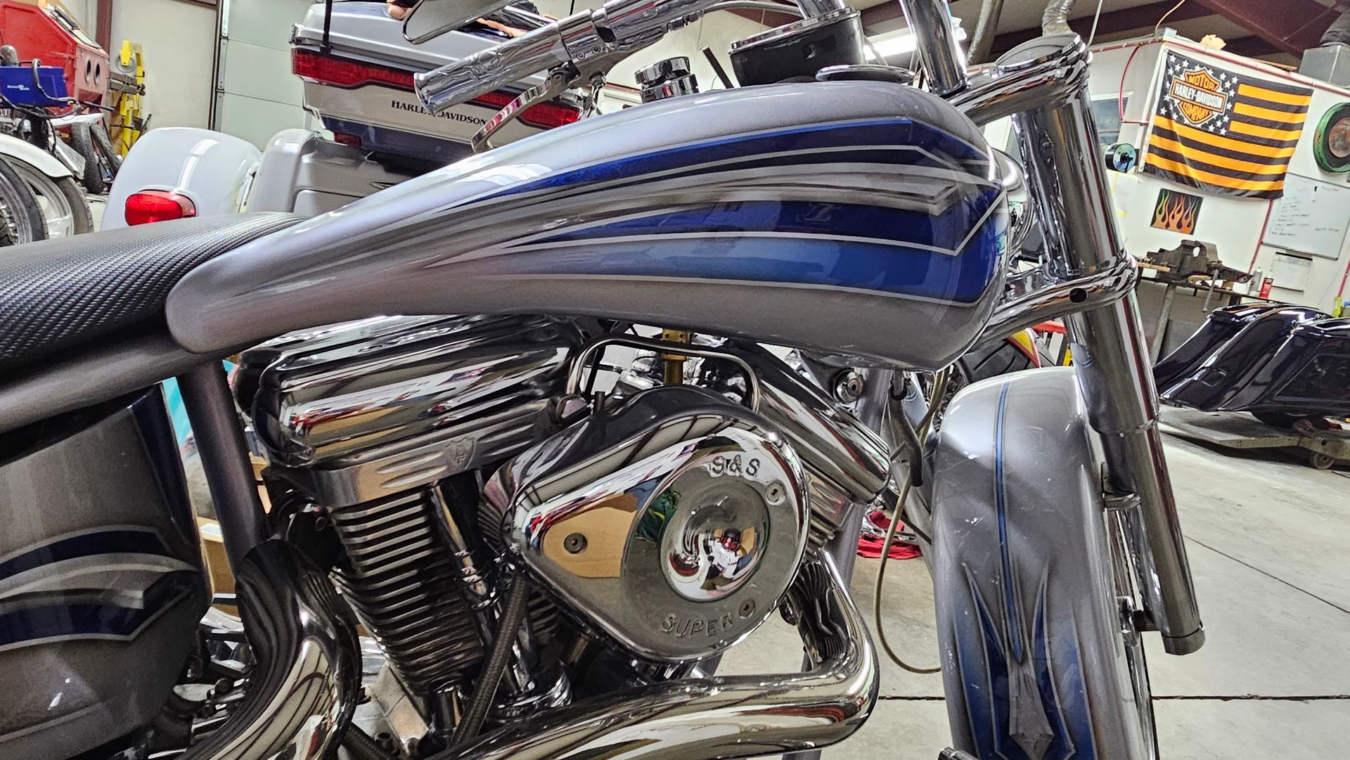 A blue and silver motorcycle is parked in a garage.