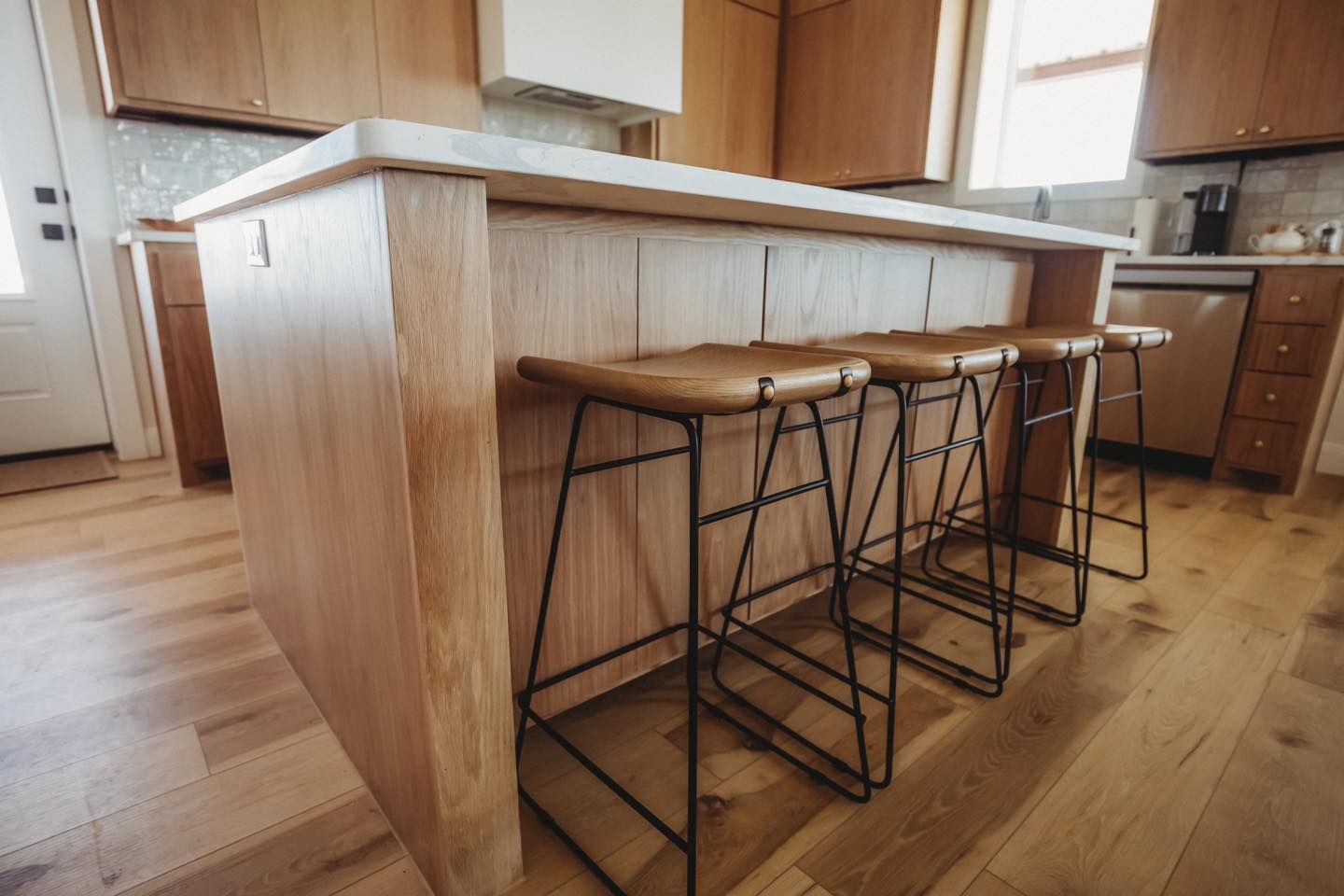 A kitchen with a wooden island and stools.