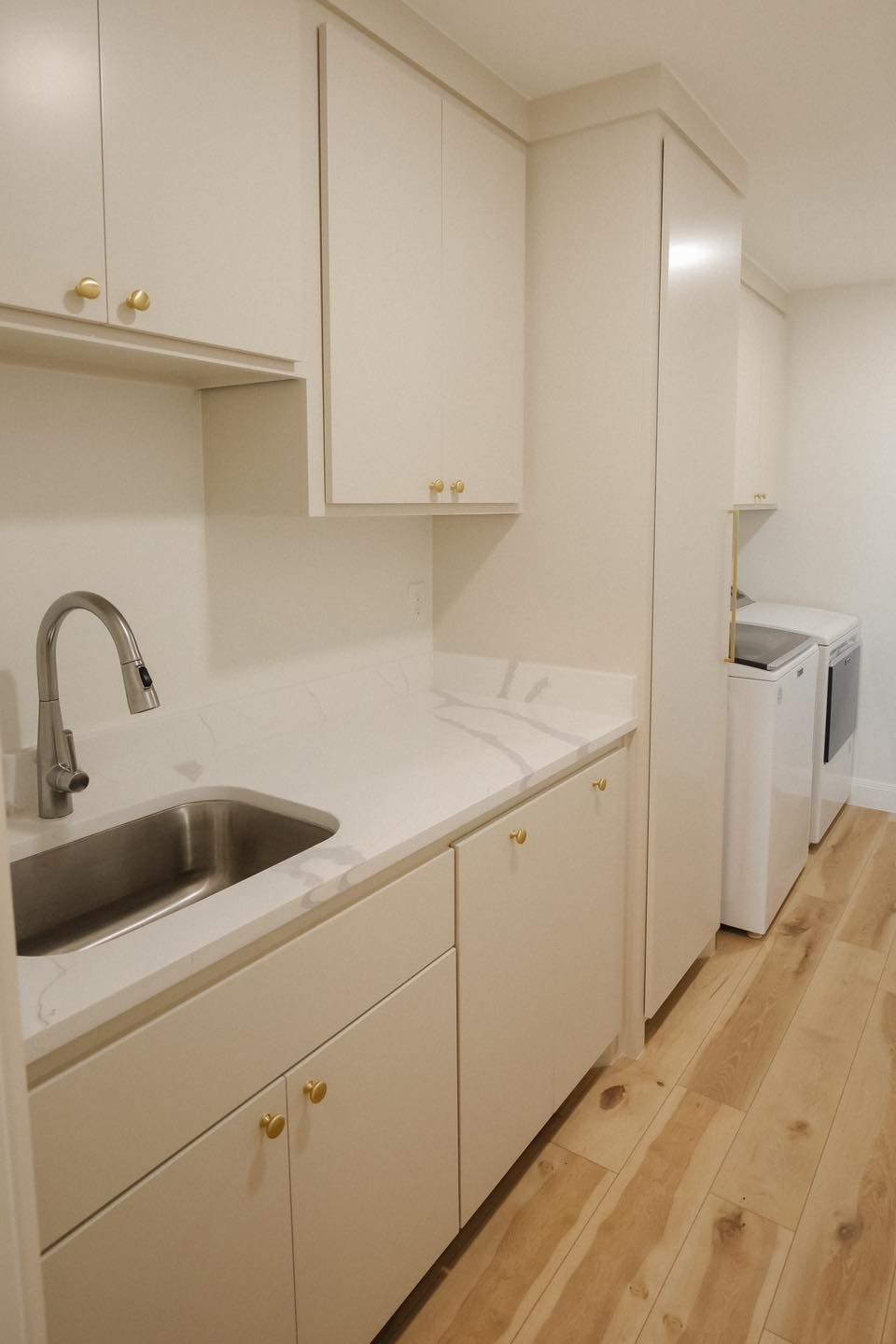 A laundry room with a sink , washer and dryer.