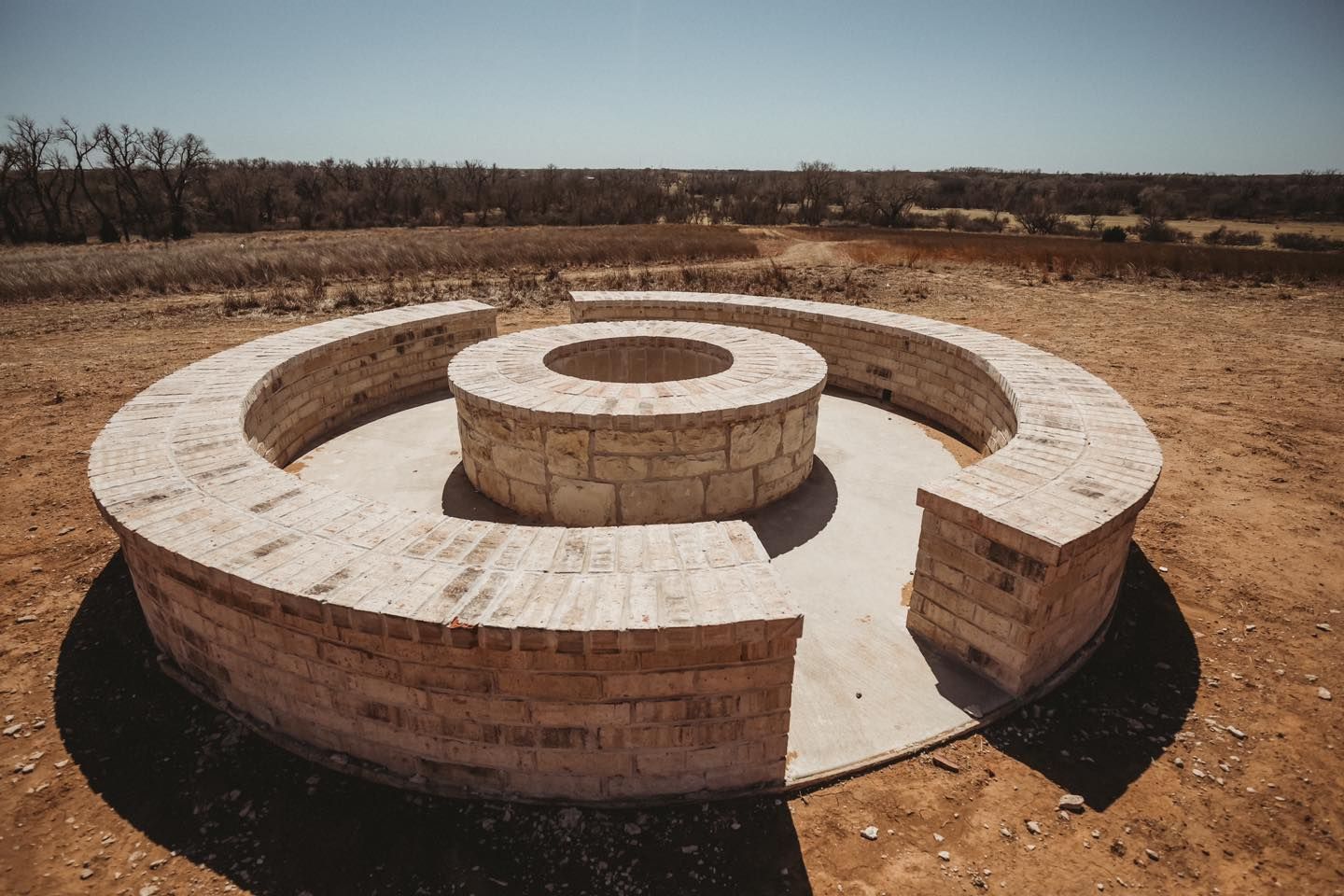 There is a fire pit in the middle of the desert.