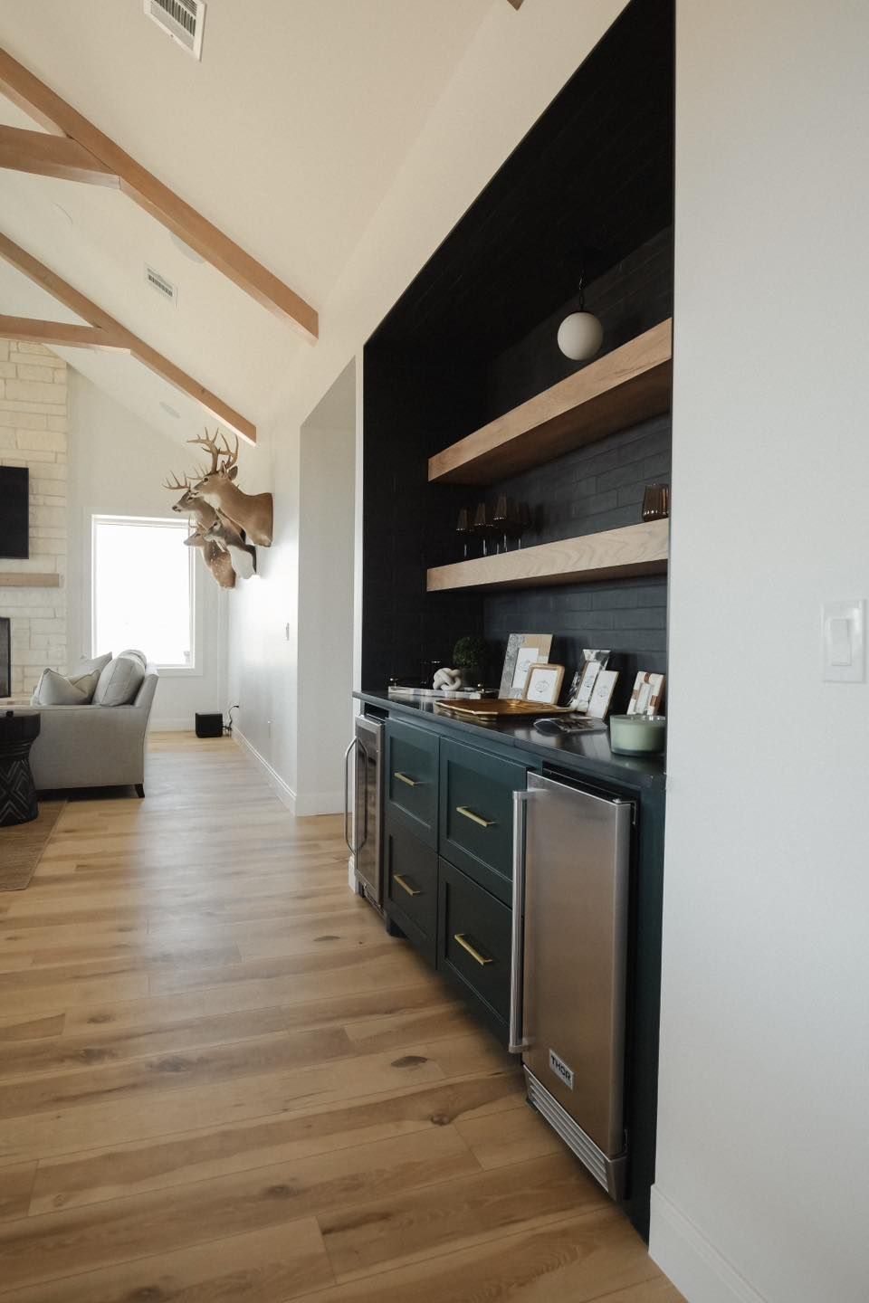 A kitchen with stainless steel appliances and wooden floors.