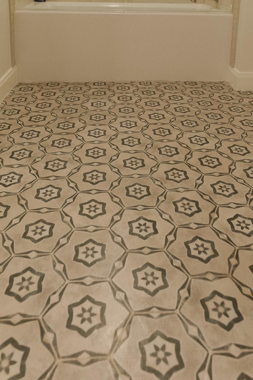 A bathroom floor with a black and white pattern