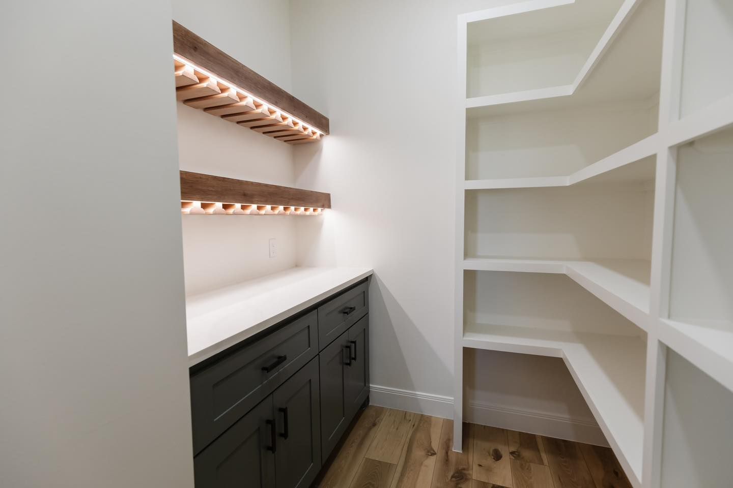A pantry with wooden shelves and a wine rack.