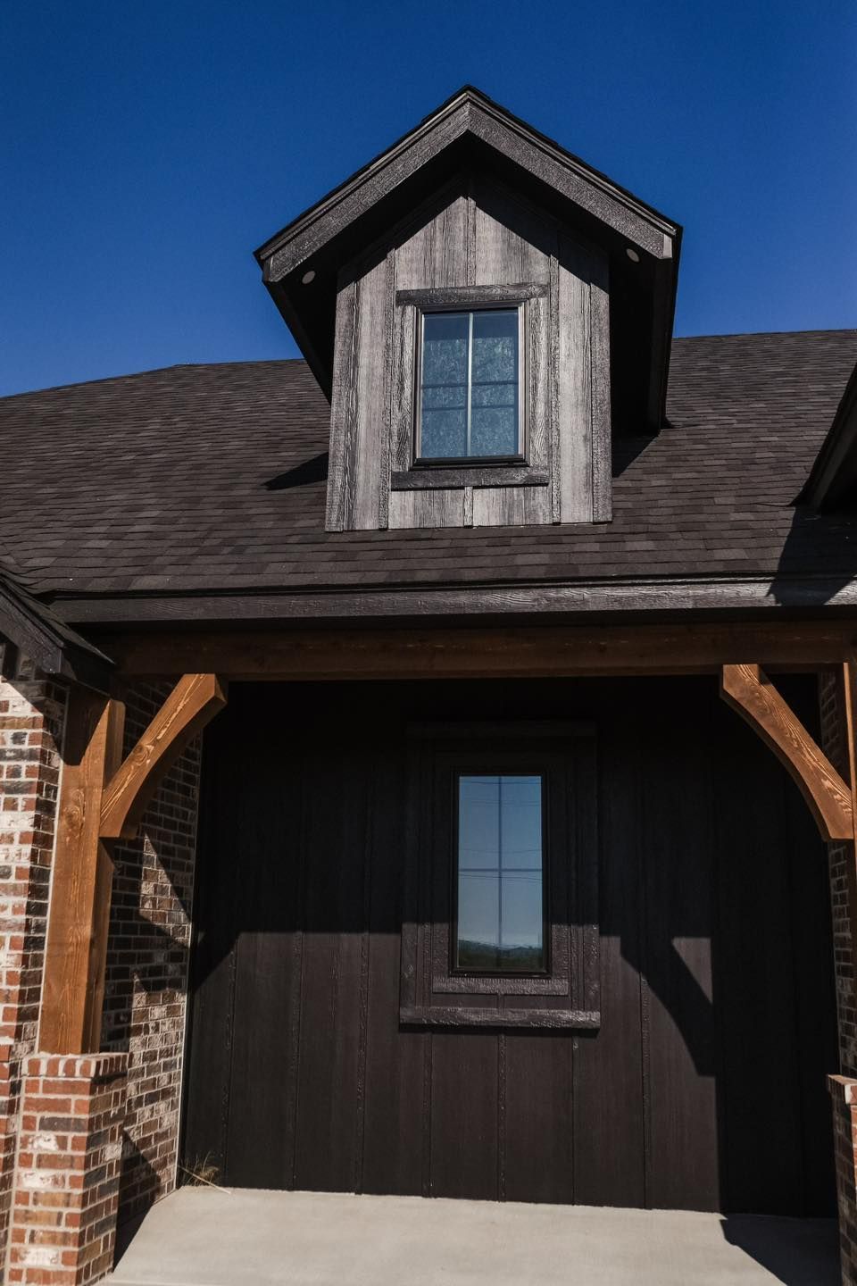 A black garage door with a window on top of it.