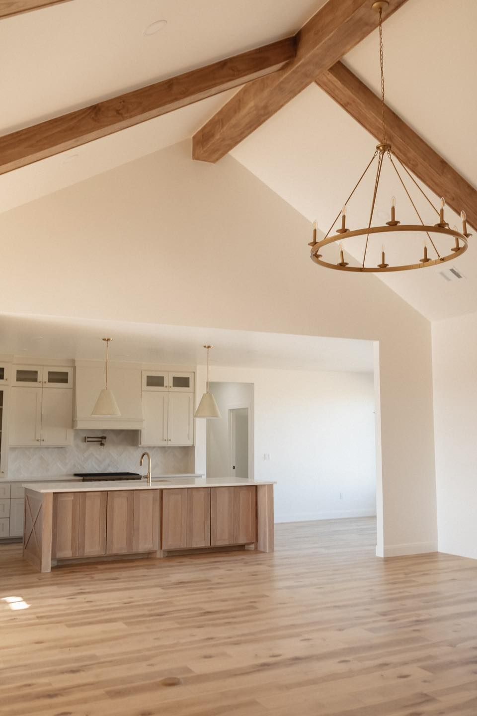 A kitchen with wooden cabinets and a chandelier hanging from the ceiling.
