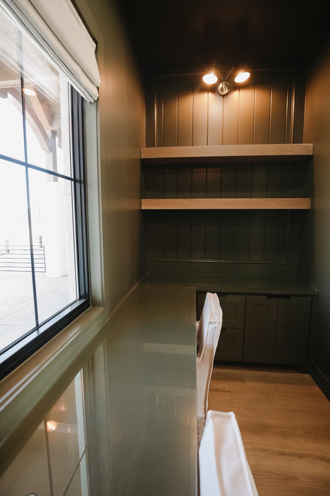 A room with a window and shelves in it.