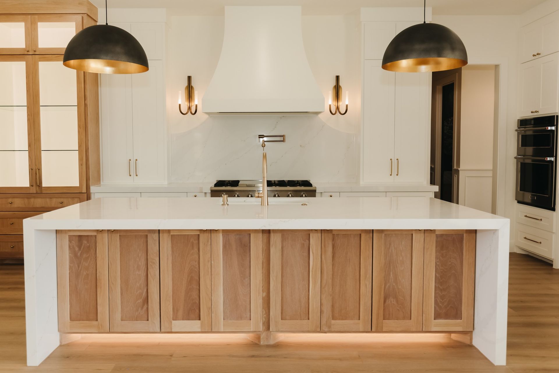 A kitchen with wooden cabinets and a large island in the middle.