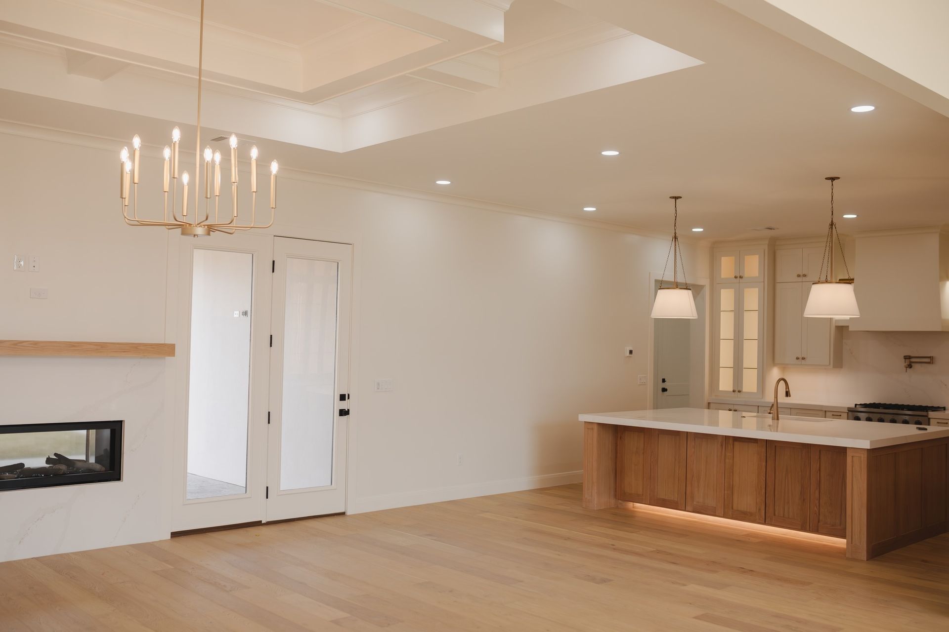 There is a fireplace in the living room and a kitchen in the background.