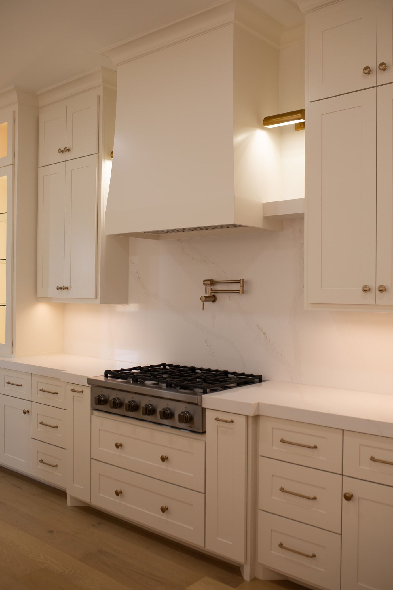 A kitchen with white cabinets and a stove top oven.